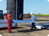 The crew (with the assistance of the Bobcat operator) begin unloading and laying out the wall panels and slide in legs.