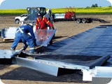 The crew (with the assistance of the Bobcat operator) begin unloading and laying out the wall panels and slide in legs.